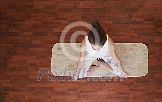 Woman sitting on the floor and meditating Woman sitting on the floor and meditating
