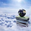 Globe on top of a pile of books reaching the sky through clouds