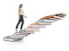 Woman climbing up stairs of books