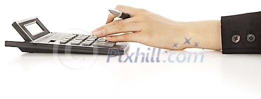 Female hand holding a pen while operating the calculator