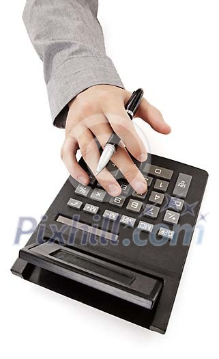 Male hand holding a pen while operating the calculator