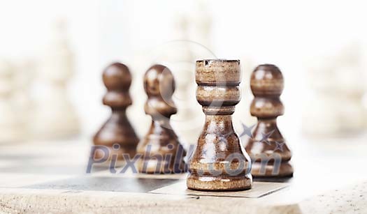 Chess pieces on board with shallow focus on rook