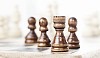 Chess pieces on board with shallow focus on rook