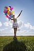Girl dancing with balloons on the grass