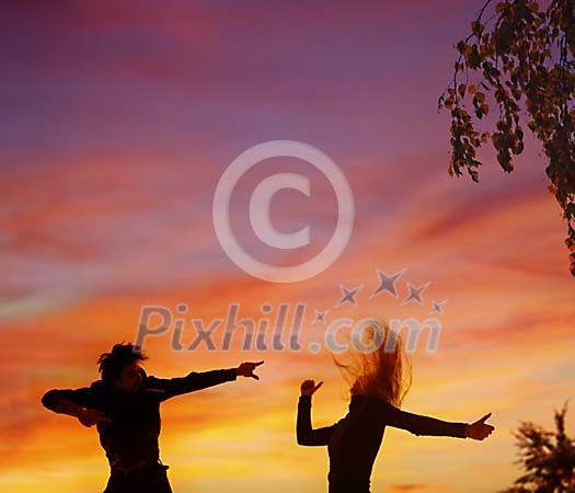 Male and female dancing on the sunset