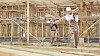 Constructors at a construction site carrying wood