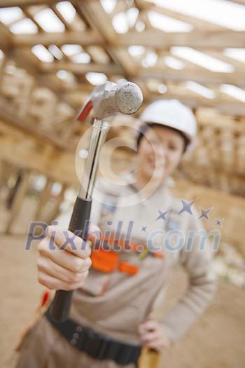 Female constructor holding up hammer