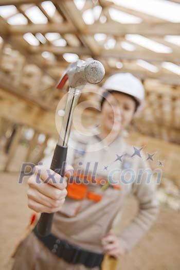 Female constructor holding up hammer Female constructor holding up hammer