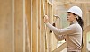 Female constructor hammering a nail