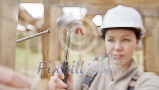 Closeup of a woman hammering a nail Closeup of a woman hammering a nail