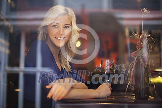Woman smiling through the wine bar window