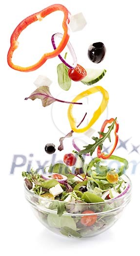 Salad ingredients falling into bowl