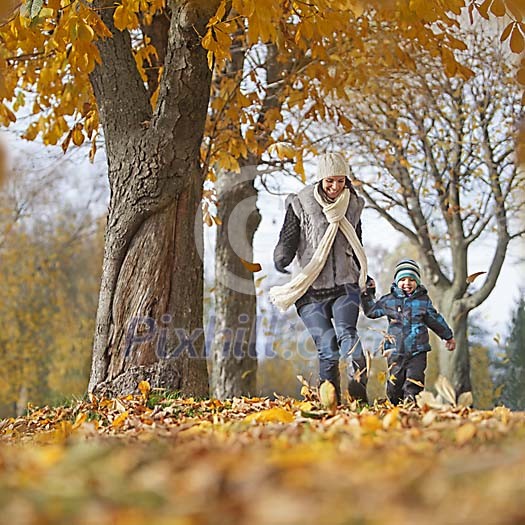 Mother and son playing with autumn leaves