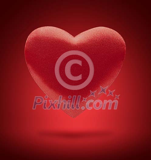 Red heart floating on red background