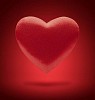 Red heart floating on red background