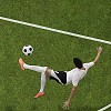Soccer player in mid air hitting ball