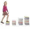 Isolated girl climbing piles of books
