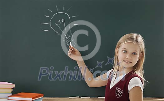 Girl drawing lamp on blackboard