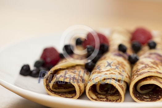 Rolls of pancakes with berries