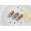 Pieces of herring with lemon slice on a plate