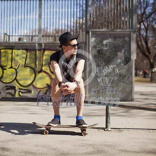 Man sitting in the park with a skateboard