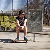 Man sitting in the park with a skateboard