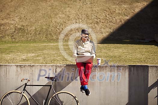 Man sitting on the grass with a laptop Man sitting on the grass with a laptop