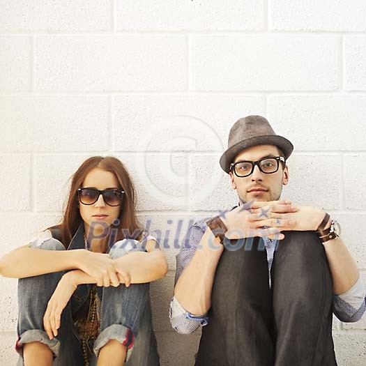 Couple sitting by the wall Couple sitting by the wall