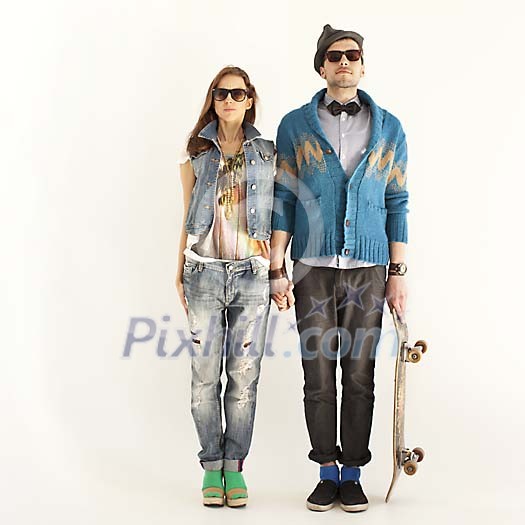 Hipster couple standing by the wall