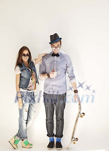 Trendy couple posing by the wall Trendy couple posing by the wall