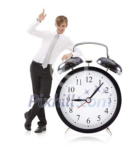 Isolated man standing next to a oversized alarm clock