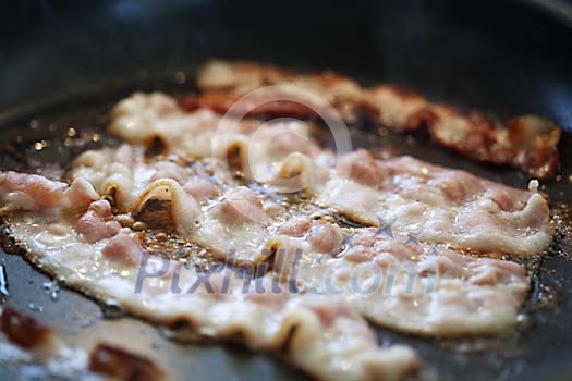 Bacon slices on a hot pan