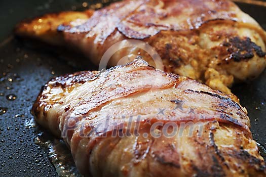 Steak covered with bacon on a hot pan Steak covered with bacon on a hot pan