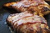 Steak covered with bacon on a hot pan