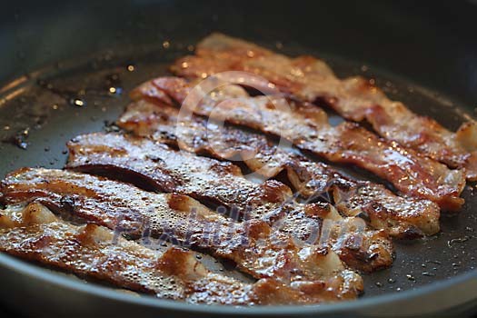 Bacon slices on a hot pan Bacon slices on a hot pan