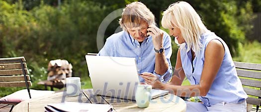 Couple sitting outside with laptop Couple sitting outside with laptop