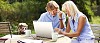 Couple sitting outside with laptop