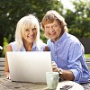 Couple sitting in the garden with laptop