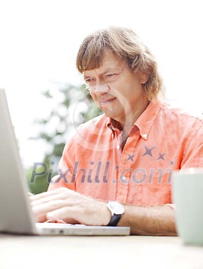 Man typing on laptop outside