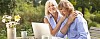 Older couple sitting outside with a laptop