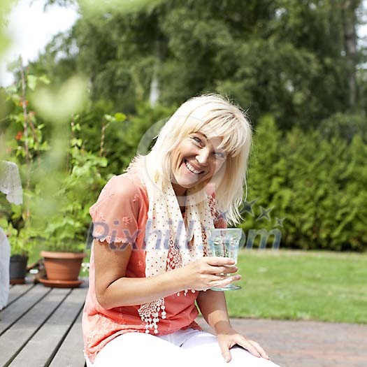 Smiling woman having a drink outside