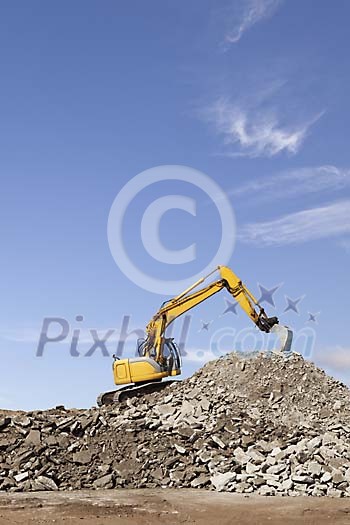 Excavator working on the rubble hill Excavator working on the rubble hill