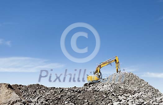 Excavator working on the crushed stone hill Excavator working on the crushed stone hill