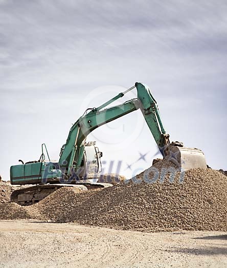 Excavator working on a rubble hill Excavator working on a rubble hill