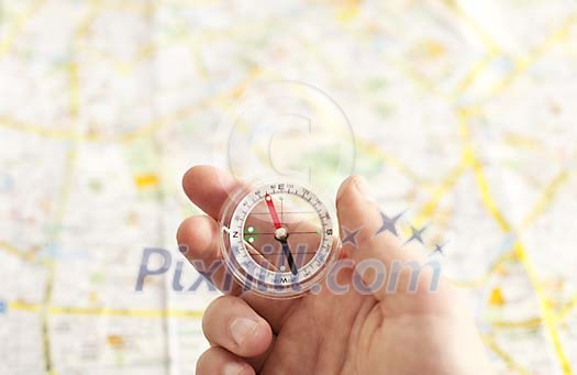 Hand holding a compass over a map background