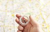 Hand holding a compass over a map background
