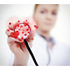 Closeup of a nurses hand holding a stetoscope with hearts on it