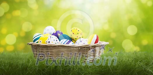 Easter eggs in basket on front of a glimmering green background