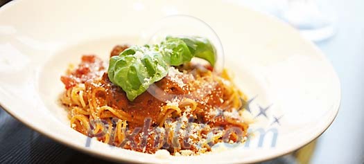 Spaghetti Bolognese with parmesan and basil leafs