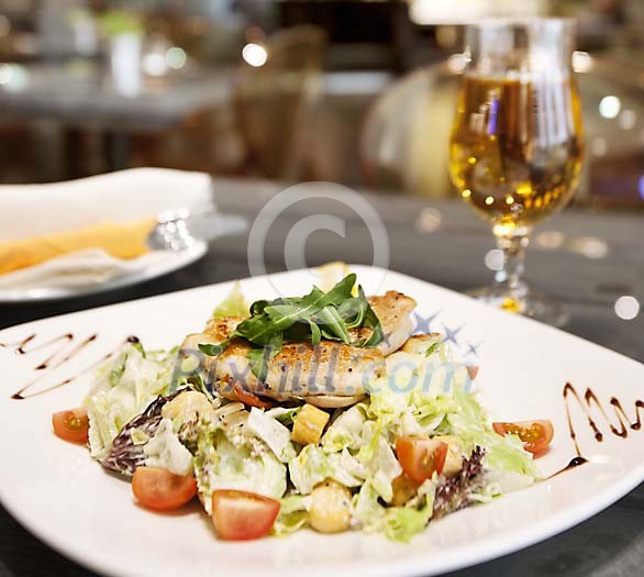 Restaurant serving of chicken and salad Restaurant serving of chicken and salad